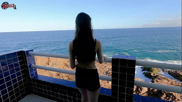 Mel strips on the balcony in front of people