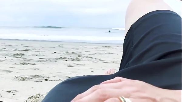 Vacationers look on with disapproval as a milf with her BF films anal content right on the beach