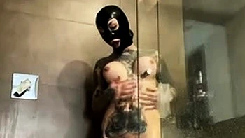 Большегрудая в латексном капюшоне дрочит в душе